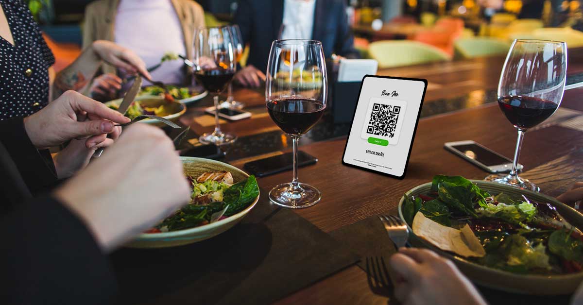 A table with a glass of wine, food and a QR code on it leverage call the service